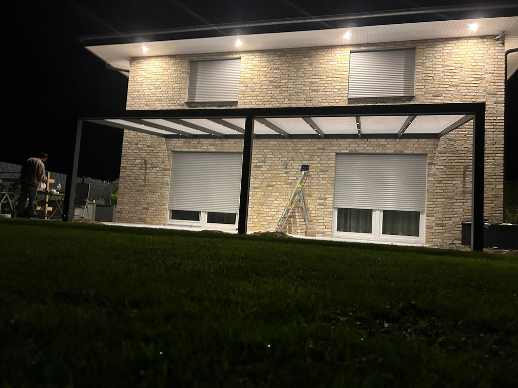 Alu Premium Terrassenüberdachung bei Nacht im Aufbau
